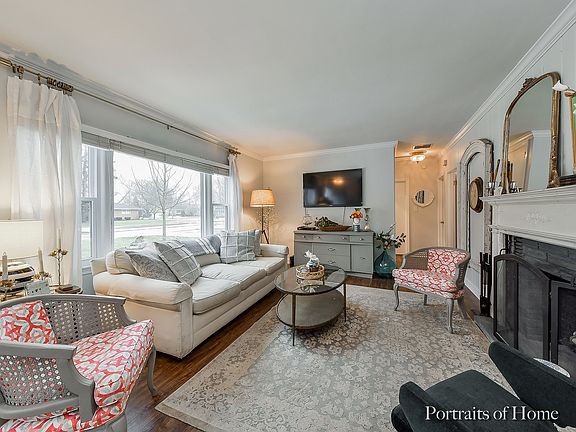 Living Room with bright picture window, crown moulding and new flooring