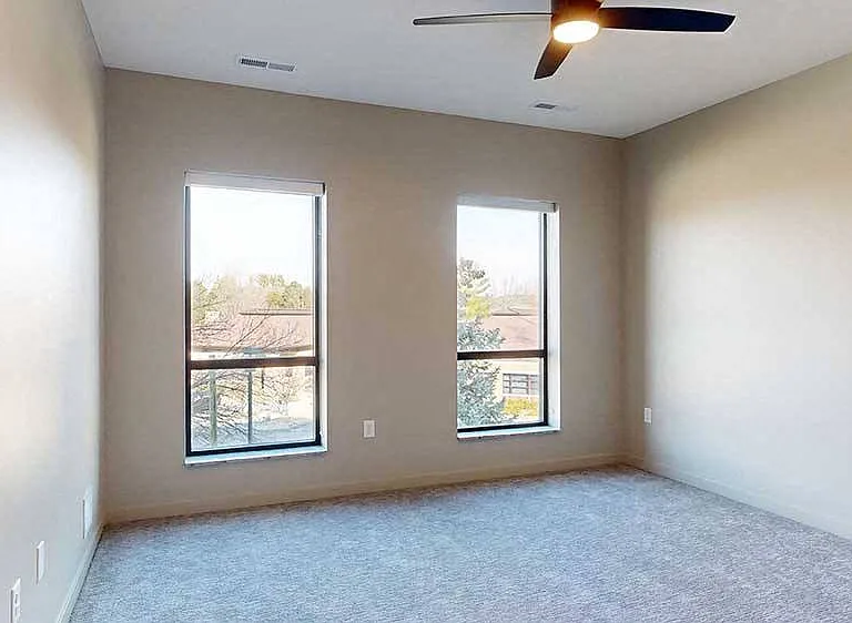 The primary bedroom offers spacious comfort with soft, neutral tones and ample natural light.