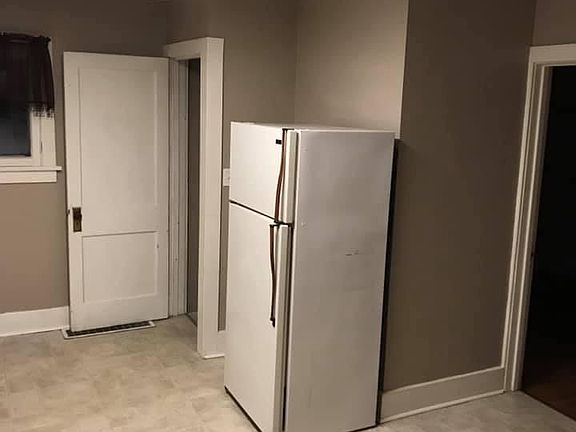 Kitchen and entry to bathroom on the right. Door to basement and attached garage on the LEFT of the refrigerator.