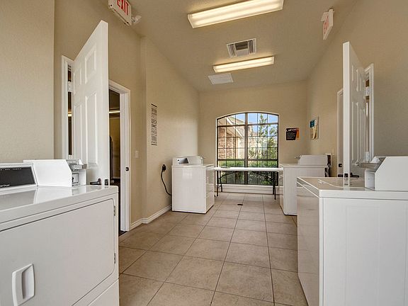 A shared laundry room with multiple washers and dryers