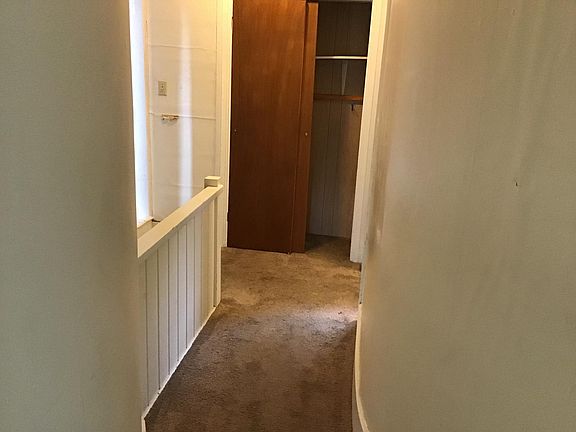 From the living room to the hall, bedroom on the left kitchen on the right. Stairs to the immediate left see the half wall.