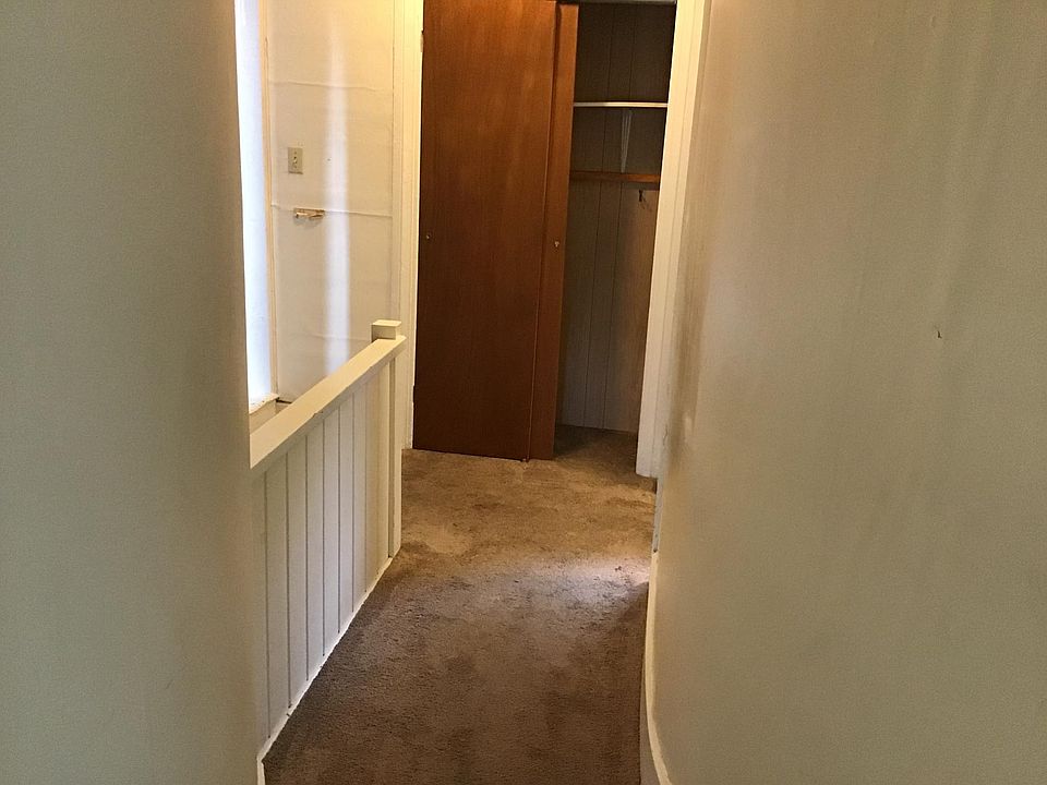 From the living room to the hall, bedroom on the left kitchen on the right. Stairs to the immediate left see the half wall.