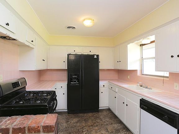 Retro look of the original tile counters is so cute. Freshly painted cabinets inside and out.
