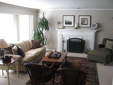 Living room with bay window, wool carpet, wood-burning fireplace