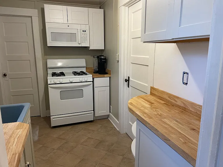 Kitchen with pots and pans dishes and coffee maker and more.