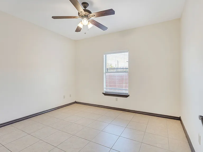 Unfurnished room with tile floors and a ceiling fan, situated in Merida Vista Apartments, Laredo, Texas