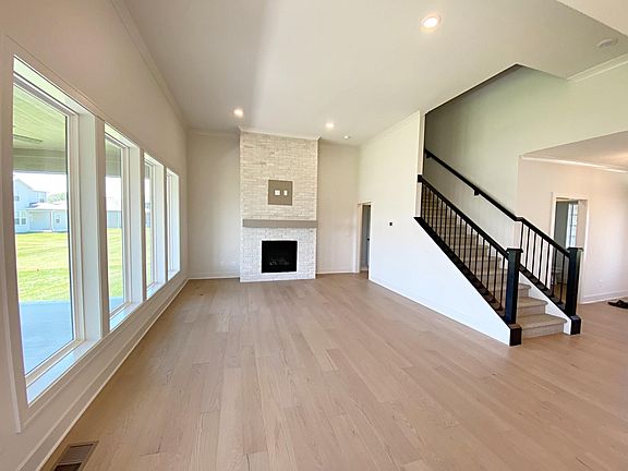 Grand living room with lots of natural light and a washed brick gas fireplace