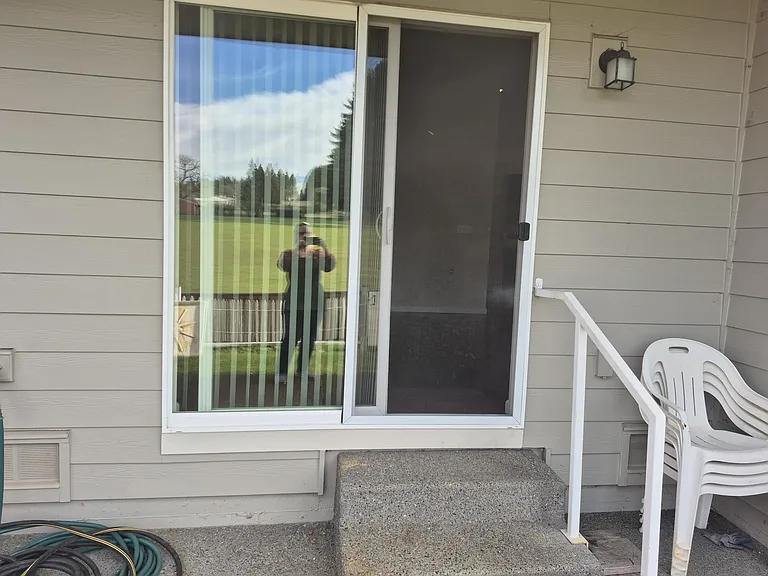 Concrete stairs and small back patio with sliding glass entrance to dining room