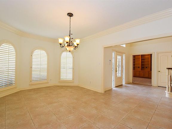 The spacious dining room offers a bay window with plantation shutters and crown molding.