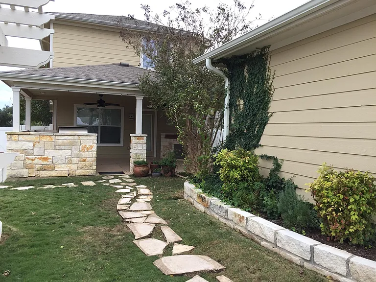 Backyard Lawn and Stone Pathway with Beautiful Plants