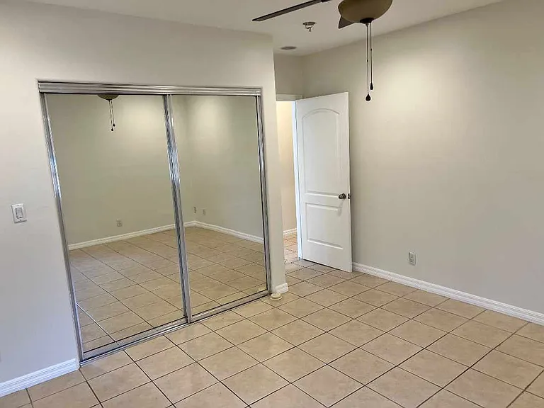 Bedroom 3 facing main hallway and standard lit mirrored closet.