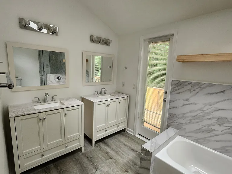 Double vanities and convenient rear door leading to the back deck