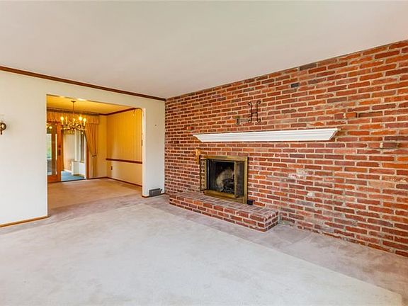 Living room has fireplace and exposed brick wall.