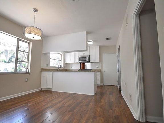 Galley Kitchen is open to the Dining Room, and both have windows with views of Lake Eustis in the distance.