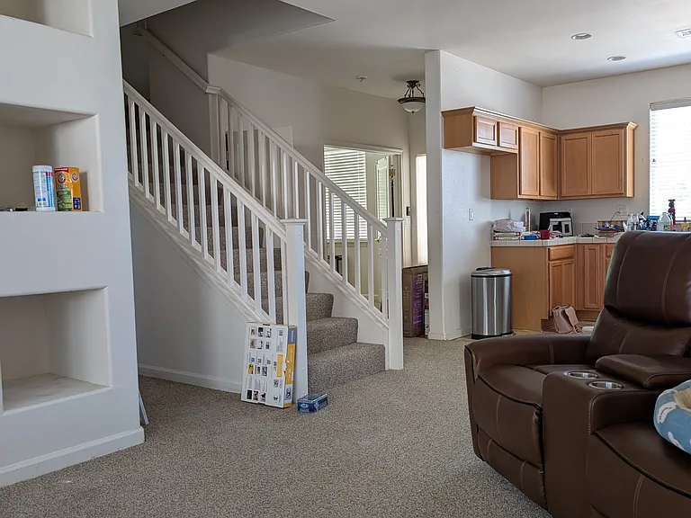 Staircase to upstairs primary suite. Downstairs has tile floor now.