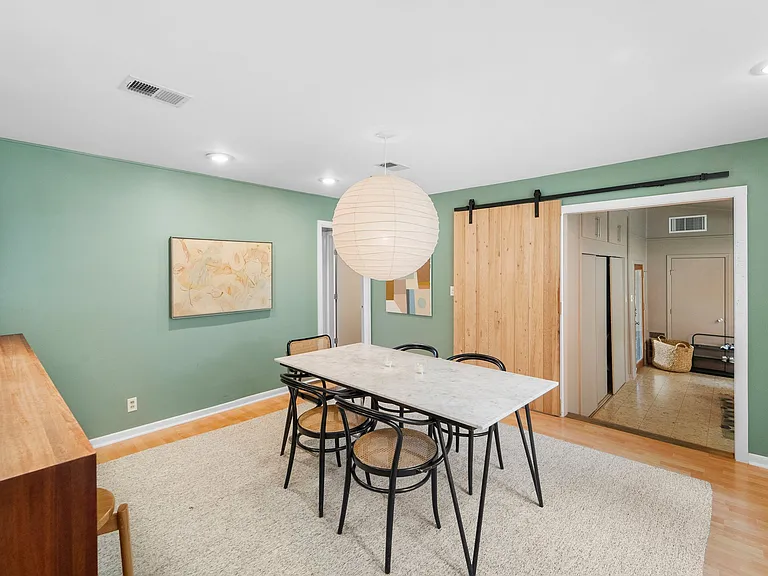 Dining opposite view. Door in back/middle to primary bedroom/bath. Doorway on right to second living area, 4th bedroom, laundry & carport