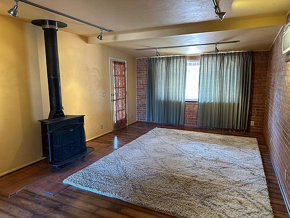 Bedroom 4/Workshop/Office: a double-size room (about 20x13) far from the other three bedrooms with a window to the south, extra private entrance, local A/C, and a closet. The stove is NOT safe to use. View to the south.