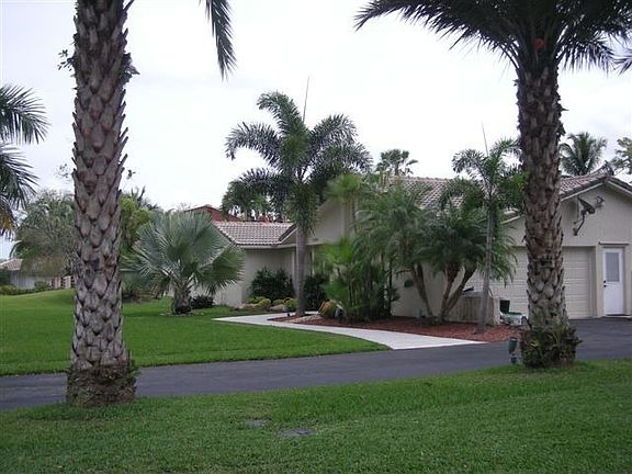 Front yard, driveway, garage & date palms