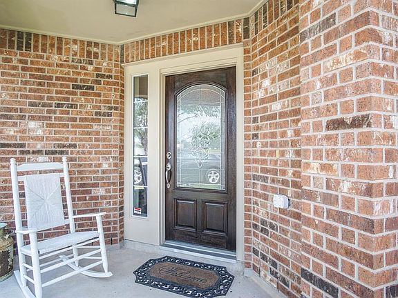 Welcoming entry with covered porch and refinished front door.
