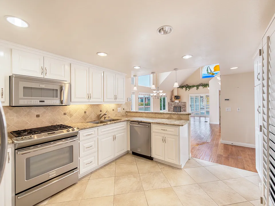 Spacious kitchen with stainless appliances, white shaker cabinetry, granite counters, recessed lights and more.