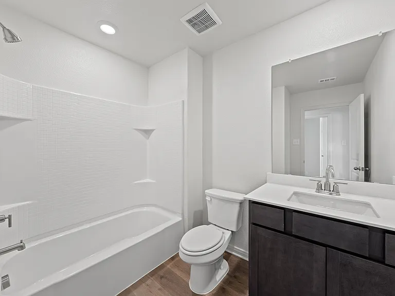 The secondary bathroom has a large vanity space and a shower-tub combo.