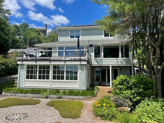 Rear of house with large deck and windows facing the water