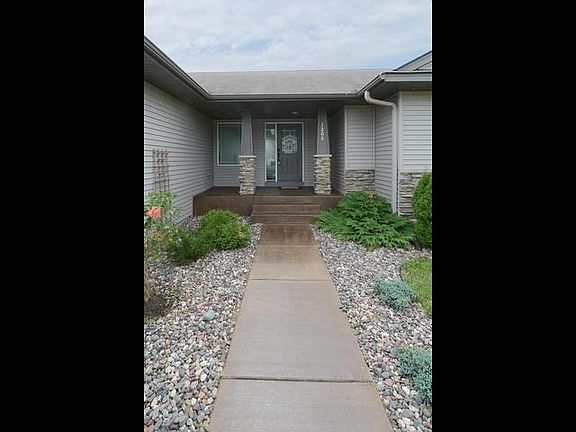 Beautifully landscaped front entry to covered porch...