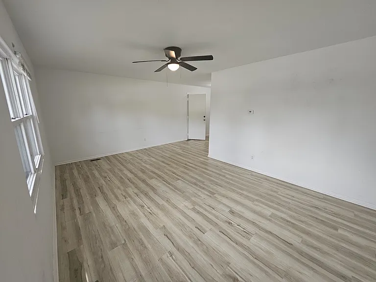 Living Room, view when entering from front door. Newly updated with hardwood floors & ceiling fan.