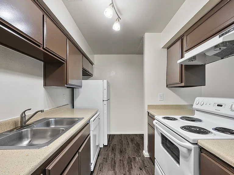 Apartment kitchen featuring generous cabinet storage, breakfast bar, and full-size appliances with a functional layout.