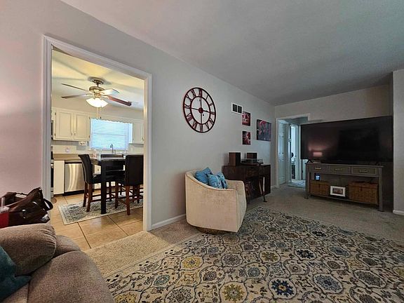 View from Living room into large kitchen, updated with all new stainless steel gas range, microwave, dishwasher, side-by-side refrigerator with ice-maker in door. Laundry area off kitchen.