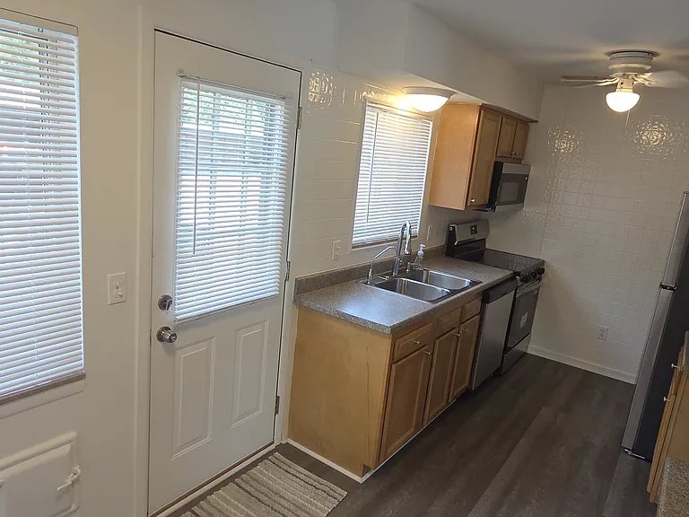 Long, functional kitchen layout with extensive cabinetry and new flooring.