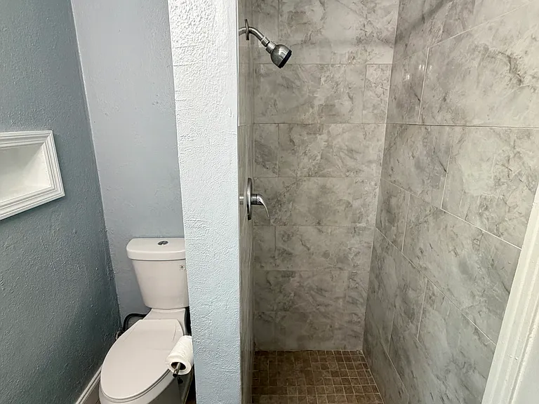 Stand-up shower with powerful shower head and built-in wall shelves