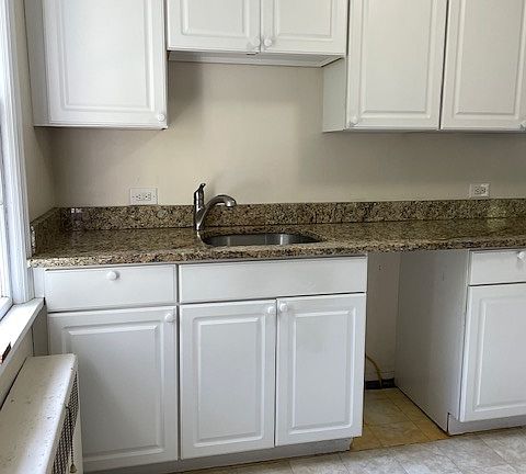 Galley style kitchen with granite countertop.