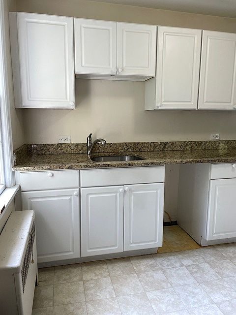 Galley style kitchen with granite countertop.