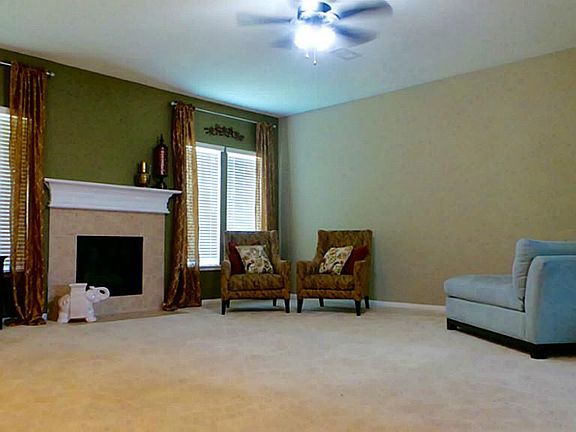 Huge living room with high ceilings, gas fireplace, ceiling fan and custom paint