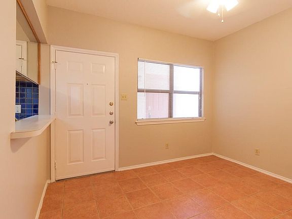 Living room view of front door & kitchen bar