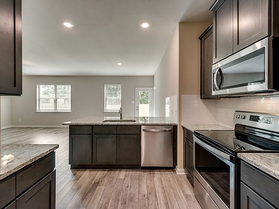 Enjoy stunning granite countertops and designer wood cabinetry in the kitchen.