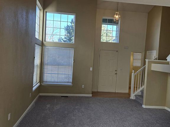 Living room area with vaulted ceinlings and a ceiling fan.