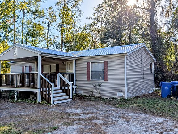 Another view of home with driveway. Driveway is made of millings. There is a 6 ft privacy fence with gate as you drive onto the property.