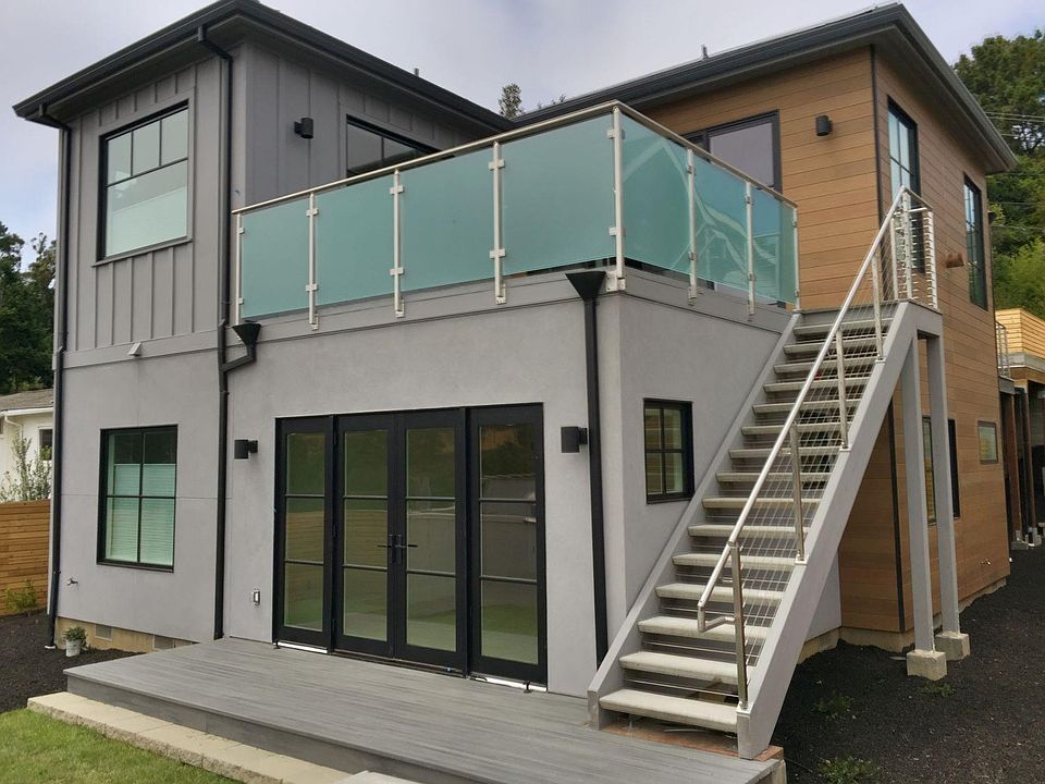 BACK ELEVATION OF PROPERTY: PRIVATE PATIO, LAWN, DECKS AND FENCED YARD.