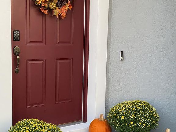 Front door with ring camera, smart lock, and brick walkway