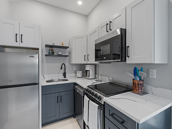 Kitchen has fridge/freezer, dishwasher, electric range, microwave, coffee maker, and toaster.