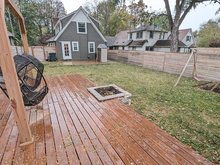 One-year old firepit, elevated deck with hanging chairs and fence.