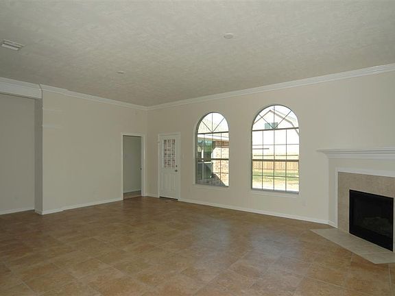 Huge family room with tile floors, high ceilings, and a beautiful fire place.