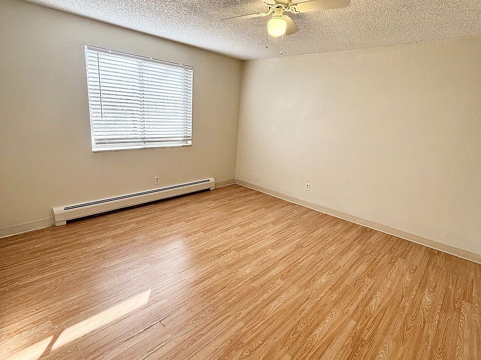 Bright, spacious room with elegant wood flooring and a modern ceiling fan, creating a welcoming atmosphere.
