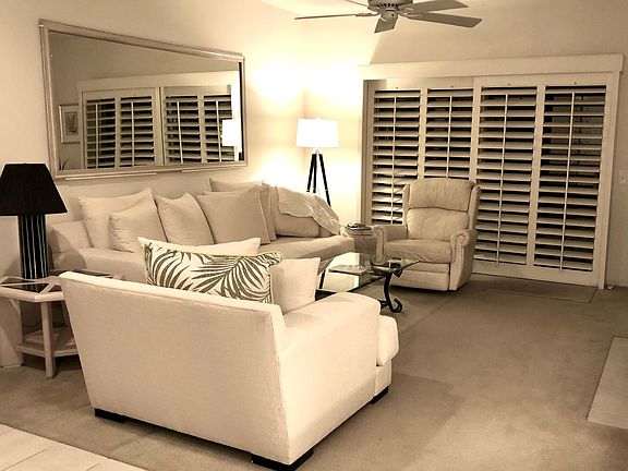 Living room with sliding doors out to the patio, with unobstructed views of the golf course and mountains.