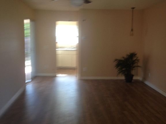 Living room with door leading into kitchen and left patio door.