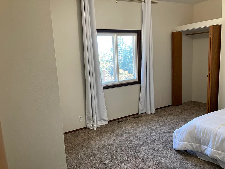 Large room (different angle), storage space above closet, black out curtain and south facing double-paned window