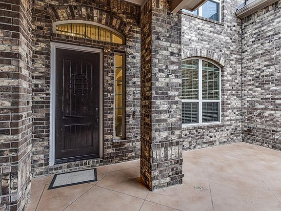 The three car garage leads to a patio at the front door area. Perfect spot for chair and table. Notice the beautiful mahogany front door.