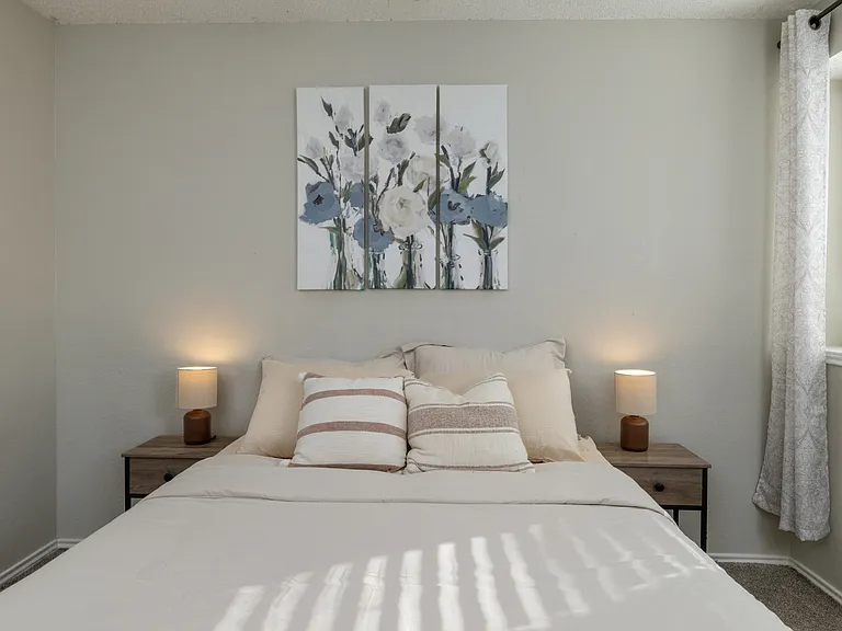 Upstairs Bedroom 3 features a queen bed, cozy carpeted floors, a ceiling fan, and plenty of natural light from the windows for a bright, inviting atmosphere.